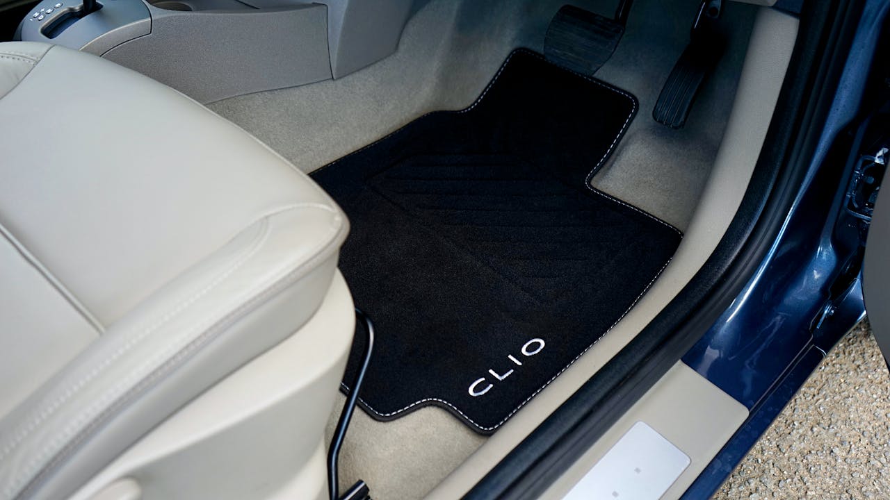 Close-up of Renault Clio car interior showcasing a customized floor mat with branding.